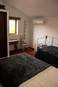 蒙丁-迪巴什图Casa Senhor da Ponte的一间卧室配有两张床和钢琴