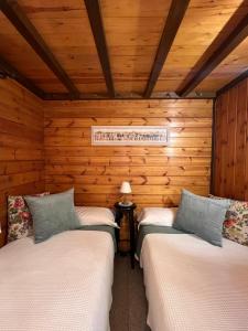 拉加玛艾佩德拉Xalet de Cal Fera的木墙客房的两张床