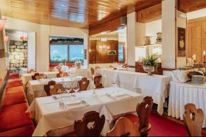 科尔蒂纳丹佩佐米拉吉酒店的餐厅配有桌椅和白色桌布