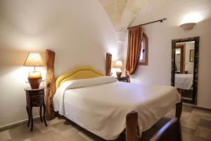 切利诺圣马尔科Tenute Al Bano的卧室配有一张白色大床和镜子