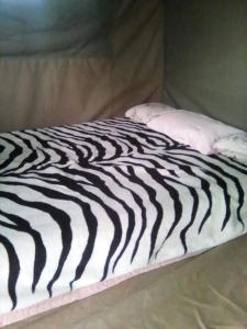 NgomaNahubwe Safari Lodge的一张黑白床,上面有枕头