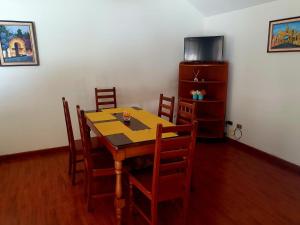 危地马拉Apartamento Aeropuerto La Aurora Guatemala的一间带木桌和椅子的用餐室