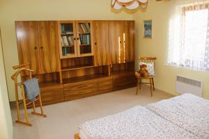 MeziměstíChalupa u Procházků的一间卧室配有木制橱柜和椅子上的泰迪熊