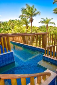 萨尔瓦多地平线乡村公寓的一个带木栅栏和棕榈树的游泳池