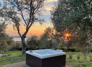 特拉西梅诺湖畔帕西尼亚诺十四世纪古朴卡萨莱酒店的花园内的热水浴池,享有日落美景