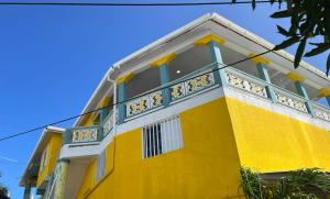 普罗维登西亚Posada buena vista al mar的黄色和白色的建筑,设有阳台