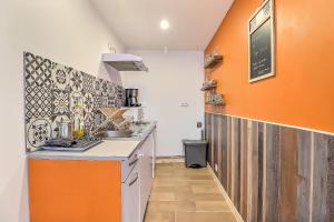 BouillarguesLe carpe diem, appt à 10 min de Nîmes的橙色和白色的厨房配有水槽和柜台
