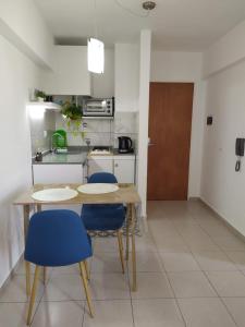 科尔多瓦Cañada Suites的厨房配有木桌和蓝色椅子