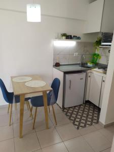 科尔多瓦Cañada Suites的小厨房配有桌子和蓝色椅子