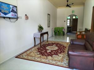 Batu RakitSofea Homestay的客厅配有沙发和桌子