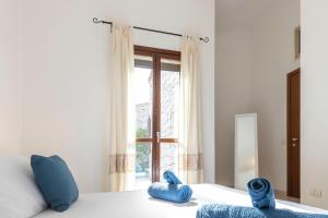 哥斯达雷Villa Sa Perda 3 - FREE WIFI - 500mt from the beach的一间卧室配有一张带蓝色枕头的床和一扇窗户。