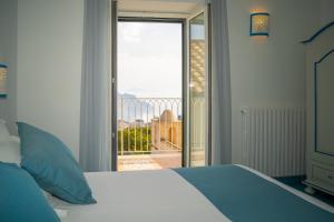 斯卡拉Ravello Dream Charming House的一间卧室设有一张床,享有阳台的景色
