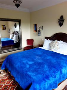 卡萨布兰卡Riad TANJIL的一间卧室配有蓝色的床和镜子
