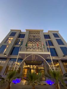 利雅德Smayah Hotel的一座高大的建筑,前面有棕榈树