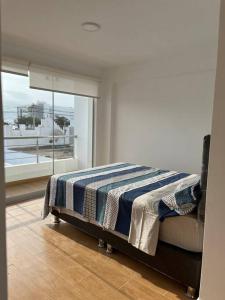 圣巴托洛SAN BARTOLO BEACH BUILDING的一间卧室配有一张带蓝白色毯子的床