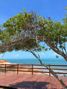 伊卡普伊Lyttos Bungalows的海滩上的树,背靠大海