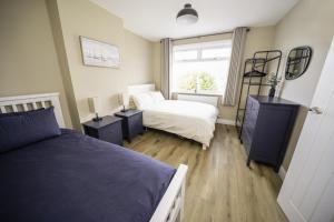 克利索普斯Highgate Beach House的一间卧室设有两张床和窗户。