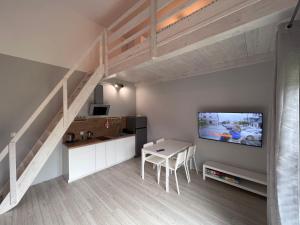 耶莱尼亚古拉Apartament Pod Jaworami z antresolą的客厅设有楼梯、桌子和电视