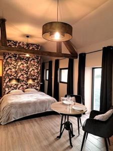 Saint-Denis-de-JouhetLa bergerie cosy - Sauna et bain nordique privatif的卧室配有一张床和一张桌子