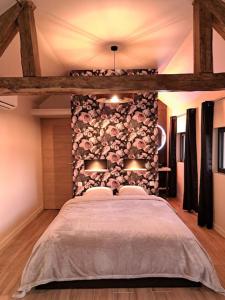 Saint-Denis-de-JouhetLa bergerie cosy - Sauna et bain nordique privatif的一间卧室设有一张大床和石墙