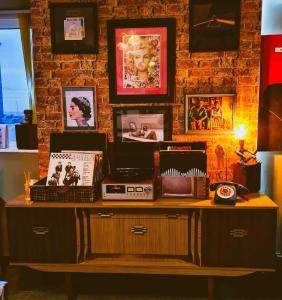 布莱克浦The Mercury, Blackpool - over 21's only的一张桌子,上面放着收音机,墙上挂着照片