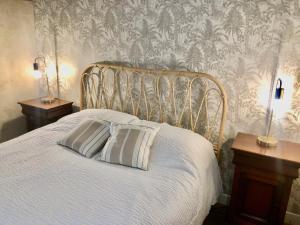 圣茹昂代盖雷特邵米尔德拉柴兹旅馆的一张带两个枕头的白色床,壁纸