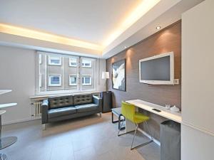 卢森堡Limpersberg - Amazing and cozy flat的客厅配有沙发和墙上的电视