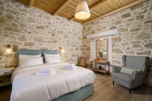 KousésPhysis Country House 2 near Matala beach & Faistos的一间卧室设有一张床和石墙