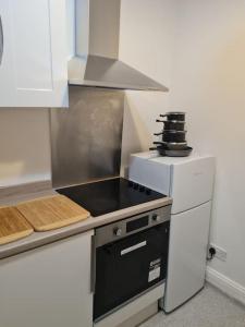 利物浦Family Home的一间带炉灶的厨房 冰箱旁的顶级烤箱