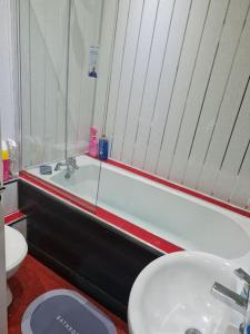 利物浦Family Home的一间带水槽、浴缸和卫生间的浴室