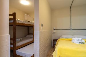 圣保罗圣保罗住宿加早餐旅舍的小客房内设有两张双层床,配有黄色床单