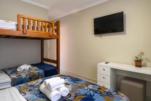 圣保罗圣保罗住宿加早餐旅舍的一间卧室配有双层床和一张带毛巾的书桌