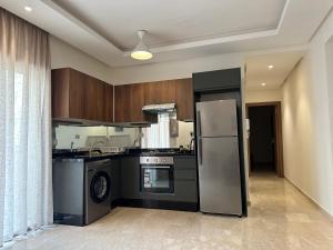 NouaceurTAJ NOUACEUR AéROPORT MOHAMMED V的厨房配有不锈钢冰箱和炉灶。