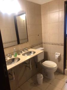 萨尔塔Departamento zona residencial CON PILETA的浴室设有2个水槽、卫生间和镜子。