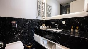 伊斯坦布尔Cihangir Residences的黑色浴室设有卫生间和水槽