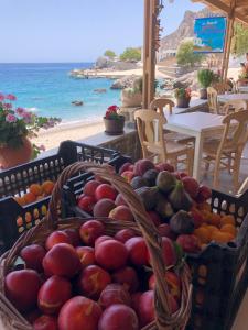 卡尔帕索斯TO VOTSALO-beach side studios & taverna的海滩附近的桌子上放着两篮水果