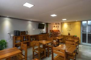 圣保罗圣保罗住宿加早餐旅舍的餐厅设有木桌、椅子和电视。