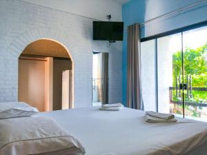 库穆鲁沙蒂巴Pousada Boa Sorte的卧室配有一张大白色床和窗户