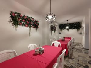 弗洛伦西亚Hotel Amazon的用餐室配有红色桌子和白色椅子