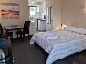 旺阿雷斯通黑文汽车旅馆的一间带一张床和一张书桌的卧室和一间厨房