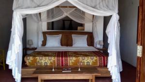 Villa Moringa lodge的一间卧室配有一张带天蓬的床