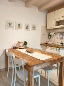 的里雅斯特Casa Vacanze Barcola的厨房配有木桌和白色椅子