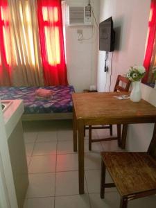 马尼拉Urban Deca Tower @ Graceysplace Unit 4 Mandaluyong的小房间设有一张床、一张桌子和一张书桌