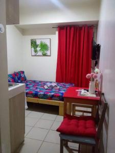 马尼拉Urban Deca Tower @ Graceysplace Unit 4 Mandaluyong的小房间,配有床和红色窗帘