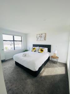 基督城Home sweet home Christchurch Centre的白色的卧室设有一张大床和一个窗户