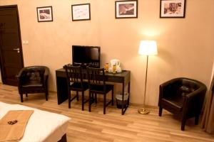 布达佩斯布达佩斯威乐住宿加早餐旅馆的客房设有一张桌子、一台电视和两把椅子