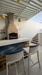 萨尔瓦多Apartamento-Cobertura de Luxo Vista Mar em Salvador的厨房配有2把椅子和比萨饼烤箱
