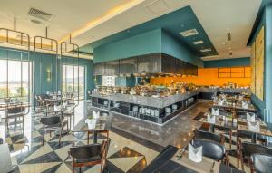 顺化La Vela Hue Hotel的餐厅设有酒吧和桌椅