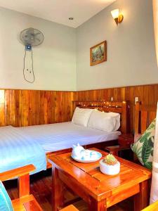 富国Liên tho Phú Quốc的酒店客房带两张床和一张桌子,