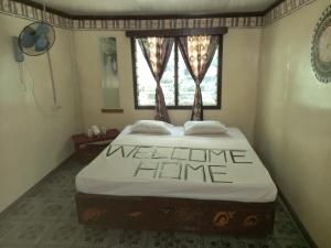 Naviti IslandWAI MAKARE HOMESTAY ROOM 2的一间卧室配有一张床,上面有迎宾家庭标志